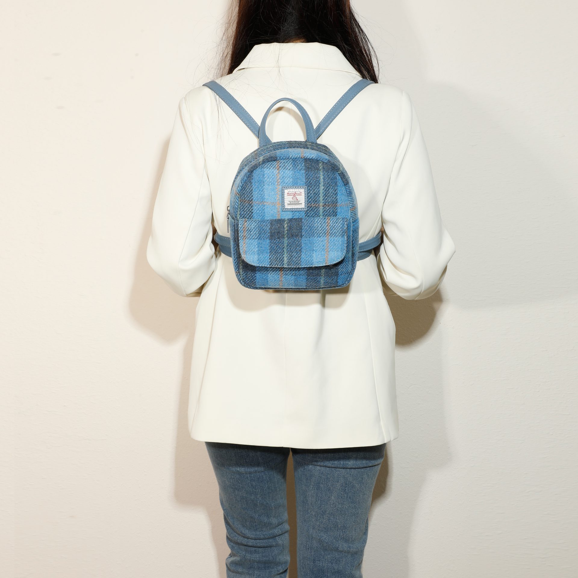 Strathurie Fashion Accessory Wholesaler Glasgow a woman wearing a white coat and blue backpack
